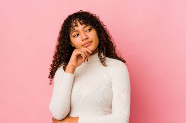 Genç Afro-Amerikan Afro kadın şüpheli ve şüpheci bir ifadeyle yanlamasına bakıyor..