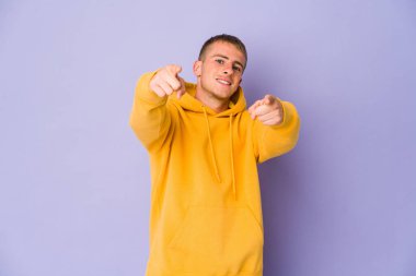 Genç, beyaz, yakışıklı bir adam. Neşeli gülücükler öne bakıyor..