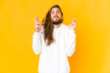 Uzun saçlı genç adam şans diliyor.