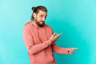 Uzun saçlı genç adam, işaret parmağıyla fotokopi alanını göstererek şok olmuş görünüyor..