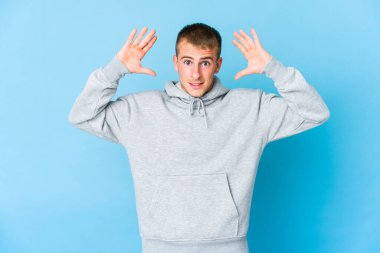 Genç, beyaz, yakışıklı bir adam zaferi ya da başarıyı kutluyor. Şaşırdı ve şok oldu..