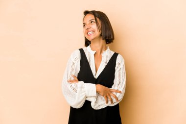 Genç İspanyol kadın izole edilmiş, rahat ve mutlu bir şekilde gülüyor, boynunda dişlerini gösteriyor..