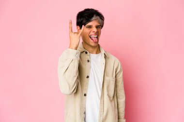 Genç, sıska İspanyol adam parmaklarıyla taş hareketi yapıyor.