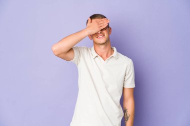 Beyaz tenli yakışıklı adam elleriyle gözlerini kapatıyor. Gülümsüyor ve bir sürpriz bekliyor..