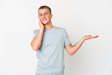 Beyaz tenli yakışıklı bir adam avucunun içinde fotokopi masası tutuyor, el üstünde tutuyor. Şaşırmış ve mutlu..