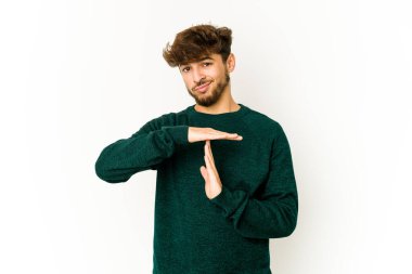 Beyaz arka plandaki genç Arap adam bir mola hareketi gösteriyor.