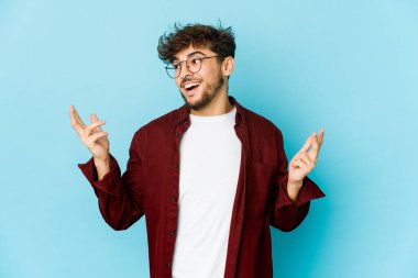 Mavi arka plandaki genç Arap adam çok gülerdi. Mutluluk kavramı.