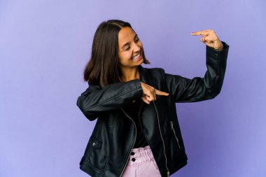 Genç melez kadın işaret parmaklarıyla küçük bir şey tutuyor, gülümsüyor ve kendinden emin..