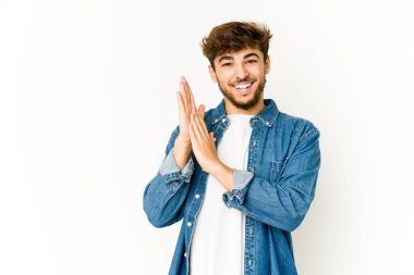 Beyaz arka planda genç bir Arap enerjik ve rahat hissediyor, ellerini ovuşturuyor..