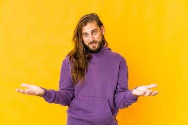 Uzun saçlı genç adam hoş bir yüz ifadesi sergiliyor..