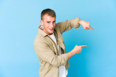 Young caucasian handsome man excited pointing with forefingers away. clipart