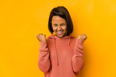 Genç İspanyol kadın, sarı bir tezahürat yapıyor ve heyecanlanıyor. Zafer konsepti.