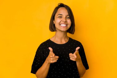 Genç İspanyol kadın, sarı neşeli gülümsemelerle izole edilmiş, önünü gösteriyor..