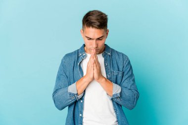 Beyaz tenli yakışıklı adam yalnız başına dua ediyor, bağlılık gösteriyor, dindar biri ilahi ilhamı arıyor..