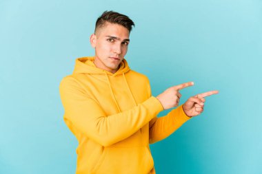 Genç, beyaz, yakışıklı bir adam izole edilmiş, işaret parmaklarıyla fotokopi alanını işaret ederek heyecan ve arzusunu ifade ediyor..