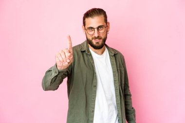 Uzun saçlı genç adam parmaklarıyla bir numarayı gösteriyor..