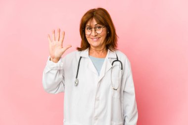 Orta yaşlı beyaz doktor kadın tebessümlü beş numarayı parmaklarıyla gösterdi..