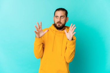 Uzun saçlı genç adam şaşırmış ve şok olmuş görünüyor..