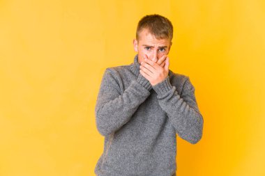 Genç, beyaz, yakışıklı, ağzı kapalı, elleri endişeli bir adam..