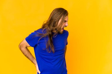 Uzun saçlı genç adam çok kızgın, öfkeli ve sinirli görünüyor..