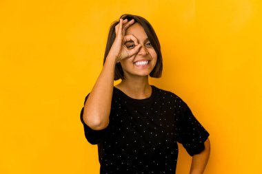 Genç İspanyol kadın sarı renkte izole edilmiş, heyecanlı, jestlerine dikkat ediyor..