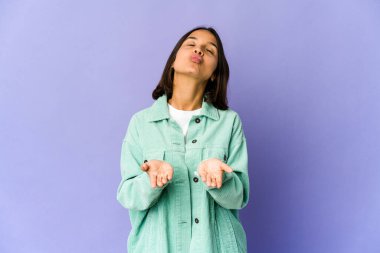 Genç melez kadın dudaklarını katlıyor ve hava öpücüğü vermek için avuç içi tutuyor..