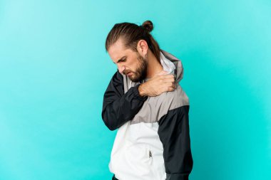 Uzun saçlı, omuz ağrısı çeken genç bir adam..