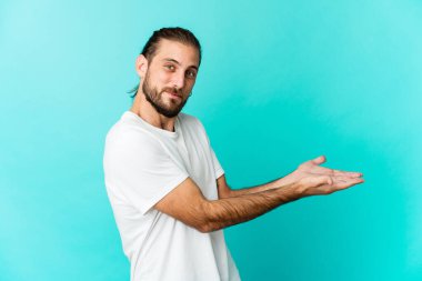 Uzun saçlı genç adam avucunun içinde bir kopya alanı tutuyor..