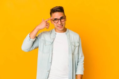 Genç, yakışıklı, beyaz, izole bir adam işaret parmağıyla hayal kırıklığı jesti yapıyor..