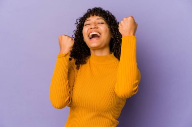 Genç Afro-Amerikan Afro kadın zafer kazandıktan sonra yumruğunu kaldırdı..