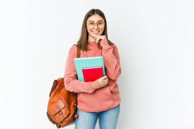 Beyaz fırında izole edilmiş genç bir bayan mutlu ve kendinden emin gülümsüyor, elleriyle çenesine dokunuyor..