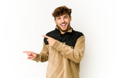 Beyaz arka plandaki genç Arap adam işaret parmaklarıyla fotokopi alanını işaret ederek heyecan ve arzuyu ifade ediyor..