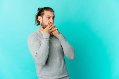 Uzun saçlı genç adam düşünceli bir şekilde bir fotokopi odasına bakıyor. Ağzını eliyle kapatıyor..