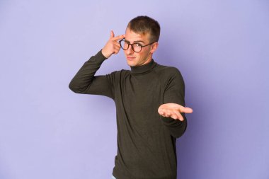 Genç, beyaz, yakışıklı bir adam elinde bir ürün tutuyor..