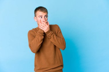 Beyaz tenli yakışıklı adam, düşünceli bir şekilde fotokopi odasına bakıyor ağzını eliyle kapatıyor..