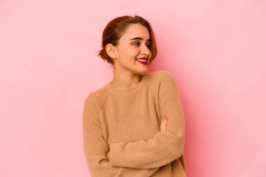 Genç Arap melez kadın kollarını kavuşturarak gülümsüyor..