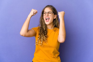 Genç, beyaz, tatlı bir kadın zaferden sonra yumruğunu kaldırıyor, kazanan konsept.