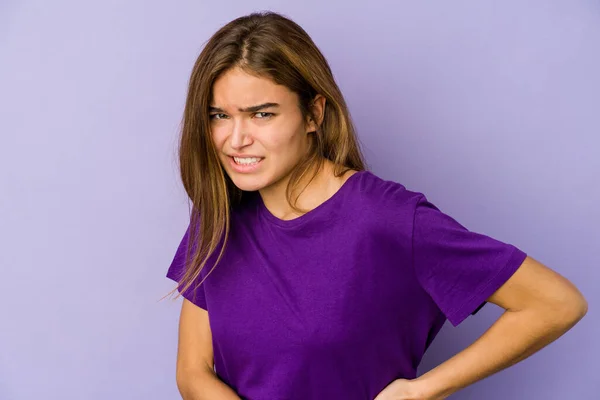 Young skinny caucasian girl teenager on purple background having a liver pain, stomach ache.