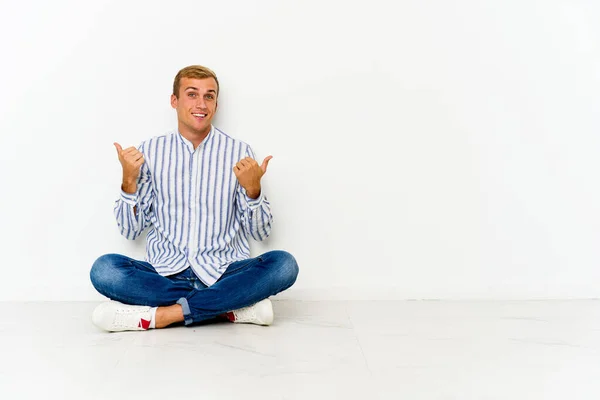 Young Caucasian Man Sitting Floor Raising Both Thumbs Smiling Confident — Stock Photo, Image