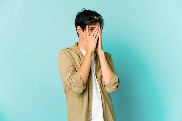Young skinny hispanic man posing on color background
