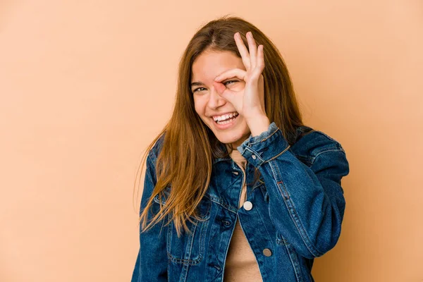 Young skinny caucasian teenager girl excited keeping ok gesture on eye.