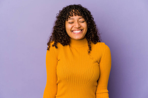 Молодая африканская американка афро женщина изолирована смеется и закрывает глаза, чувствует себя расслабленным и счастливым.