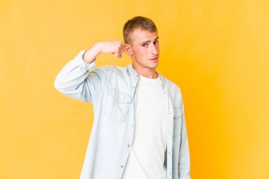 Beyaz tenli yakışıklı bir adam gömleğinin fotokopi odasını gösteriyor, gururlu ve kendinden emin.