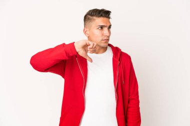 Genç, beyaz, yakışıklı, izole edilmiş, baş parmağını aşağı gösteren ve hoşlanmadığını ifade eden bir adam..