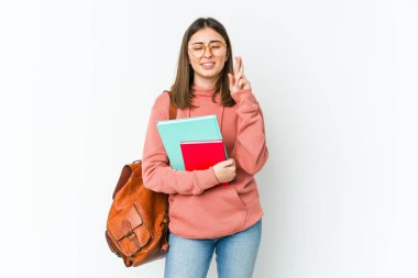 Genç bayan öğrenci, beyaz bakkalda izole edilmiş şans dilemek için şans diliyor.