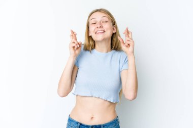 Genç sarışın kadın beyaz arka planda izole edilmiş şans dilemek için şans diliyor.