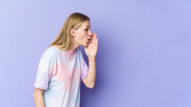 Mor arka planda izole edilmiş genç sarışın kadın gizli bir sıcak fren haberinin olduğunu söylüyor.