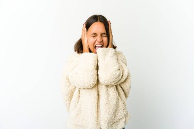 Genç melez kadın, kulaklarını ellerinle kapatıyor ve yüksek sesli sesler duymamaya çalışıyor..