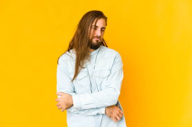 Uzun saçlı genç adam tekrarlanan bir görevden yorgun görünüyor..