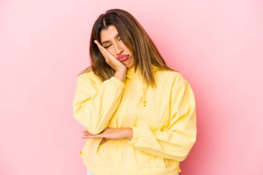 Pembe arka planda izole edilmiş genç Hintli kadın sıkılmış, yorgun ve dinlenmeye ihtiyacı var..